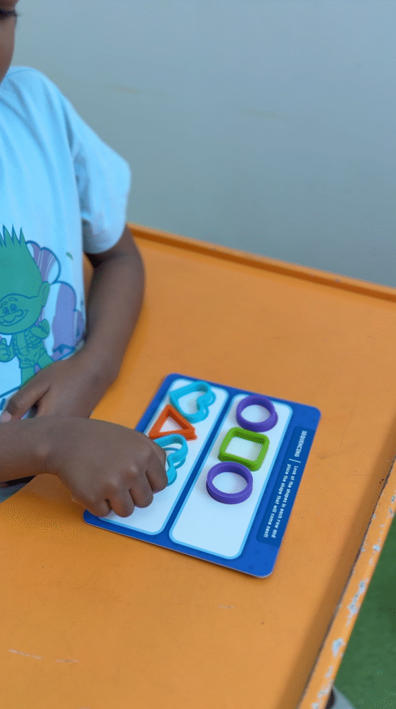 Child working on a shape and color matching activity as part of sensory integration therapy at Jewel Autism Center, Dubai.